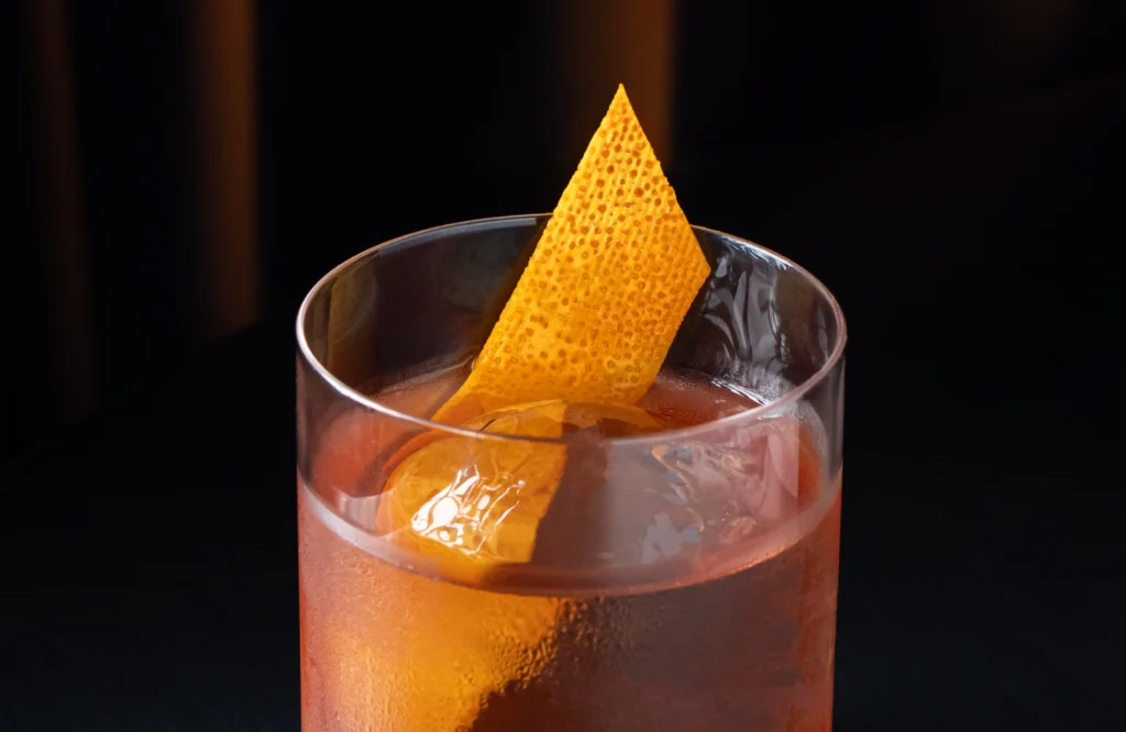 Cóctel Volcán con Tequila 1800 Reposado y Carpano Rosso servido en vaso old fashioned con hielo y twist de toronja.