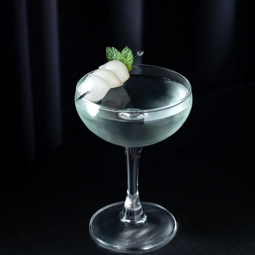 Cóctel Gibson 1800 con vermouth y Absinth servido en copa martinera con brocheta de bambú y cebollitas encurtidas.